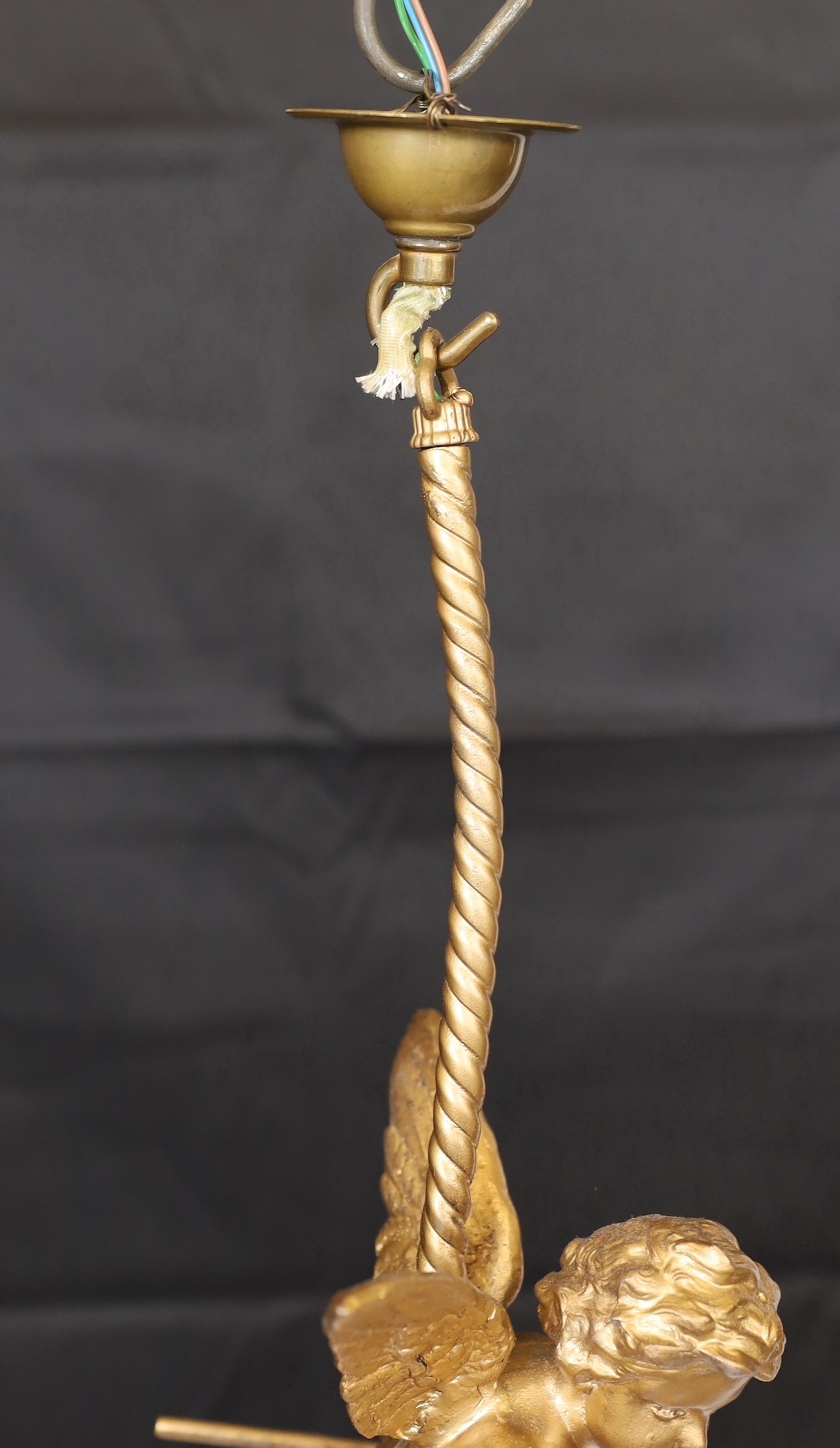 A 1920s English gold painted spelter Cupid light fitting with coloured glass shade, height 54cm. width 24cm